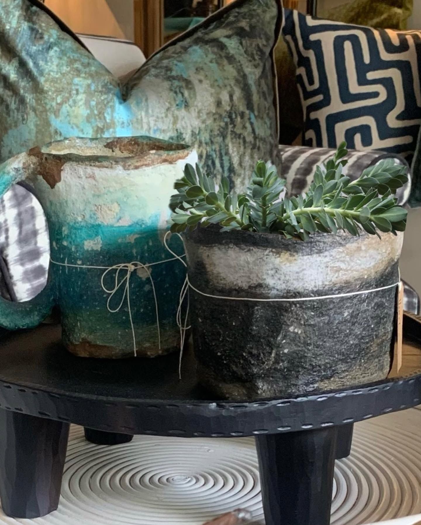 Hand-finished vessels and a succulent on a dark carved table