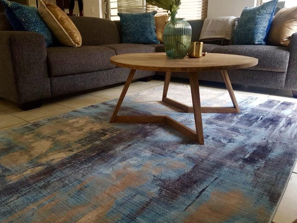 Lounge with a round timber coffee table and a blue rug
